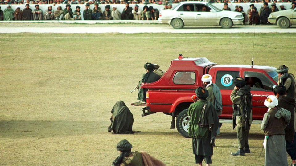 OFFENTLIGE HENRETTELSER: Dette bildet fra mars 1998 viser en antatt skyldig drapsmann, knelende foran 35 000 tilskuere p� fotballarenaen The National Stadium i Kabul, kort tid f�r han blir henrettet. Foto: AFP PHOTO/Stefan SMITH/SCANPIX