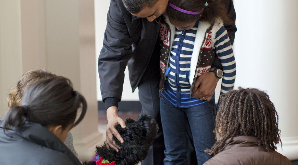 FLYTTEDAG: Barack Obama introduserer Bo for yngstedatteren Sasha (7), mens kona Michelle og s�steren Malia (10) ser p�. Foto: AFP PHOTO/HO/The White House/Pete Souza/SCANPIX