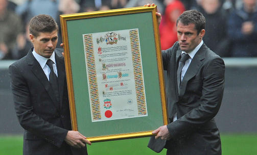 SELVSKREVNE: Kaptein Steven Gerrard (t.v.) og visekaptein Jamie Carragher var selvf�lgelig til stede under ettermiddagens minnemarkering p� Anfield. De bidro blant annet med � avduke denne �resbevisningen til Hillsborough Families Support Group, som har viet store deler av sin tid til de p�r�rerende etter tragedien i Sheffield for 20 �r siden. Foto: SCANPIX/AFP PHOTO/PAUL ELLIS