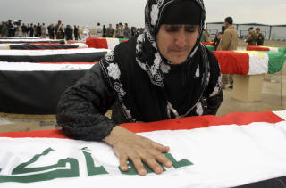 S�RGER: En kvinne s�rger over en slektning, funnet i en massegrav i Irbil. Foto: AP Photo/Yahya Ahmed/Scanpix
