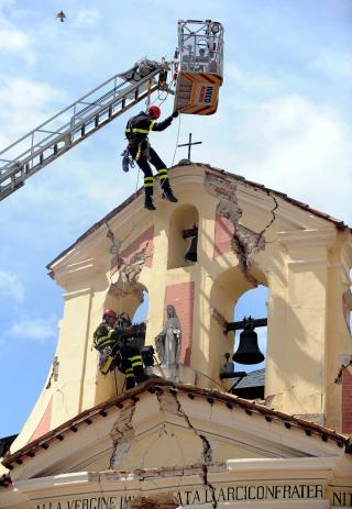 BERGING: En statue av Madonna blir reddet fra et kirket�rn i Paganica. En rekke verneverdige bygg fra middelalderen ble knust i jordskjelvet. Foto: Scanpix/ EPA/ETTORE FERRARI