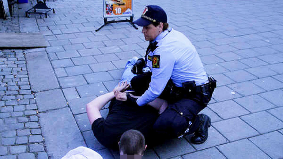 TO P�GREPET:  En st�rre gruppe fotball-p�bler barket i ettermiddag sammen i et masseslagsm�l ved Nationaltheateret i Oslo. Her p�griper politiet en av de involverte. Ytterligere �n person er p�grepet. Foto: Espen Hovde