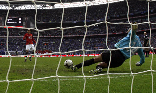 PARADE: Tim Howard var p� vei mot h�yre, men ballen kom ikke raskere fra Berbatov enn at han klarte � stoppe den med beina som fortsatt sto igjen i midten av m�let. Foto: SCANPIX/AP/Jon Super