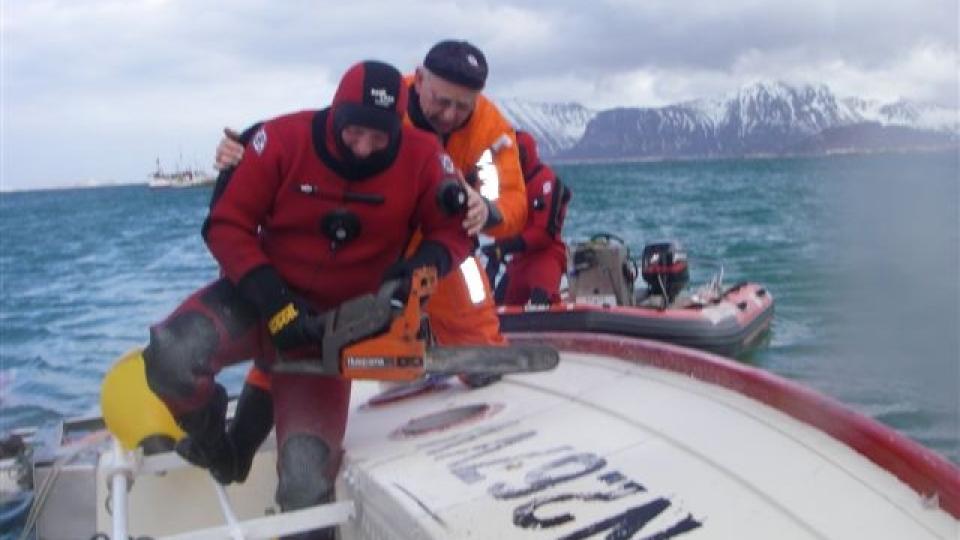 SAGER HULL: Maskinist p� RS Gjert Wilhelmsen, Ove H�yem fra Tr�ndelag, sager hull i skroget med motorsag. Foto: Redningsselskapet.