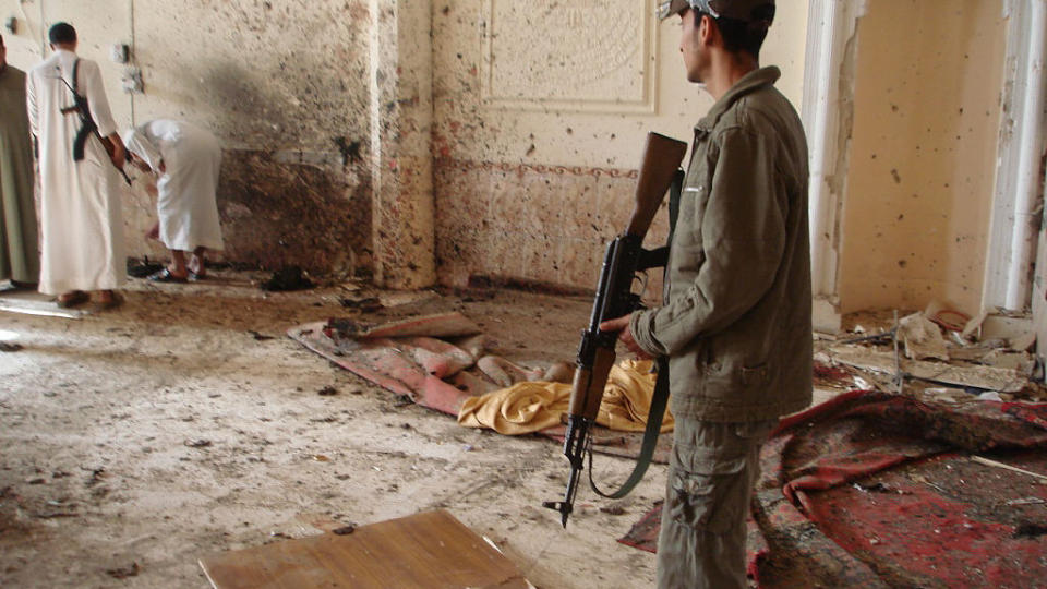 FOR SENT: Tragedien er allerede et faktum n�r denne politimannen ankommer moskeen i Dhuluiyah, hvor fire mennesker ble drept i g�r. Angrepet er et av flere i en b�lge av selvmordsangrep som har herjet Irak det siste d�gnet.. Foto: AFP PHOTO/Mahmud Saleh/Scanpix