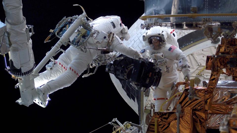 TWITRER FRA ROMMET: Nasa-astronaut Mike Massimino (venstre), her fotografert under et oppdrag i 2002, skal fors�ke � sende Twitter-meldinger mens han g�r i bane rundt jorda i mai. Foto: AP/NASA