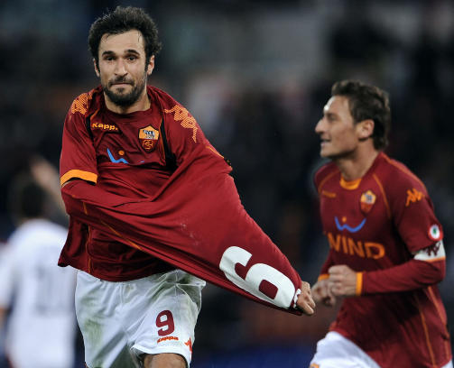 FEIGING: Roma-spiss Mirko Vucinic dro av seg drakta etter en scoring mot Cagliari tidligere denne sesongen, men ikke for � vise fram brystkassa. Han ville bare vise fram - eh... - en helt lik drakt han hadde under. Foto: AFP