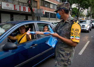HJELP: Soldater deler ut munnbind. Foto: AFP PHOTO/Luis Acosta/Scanpix