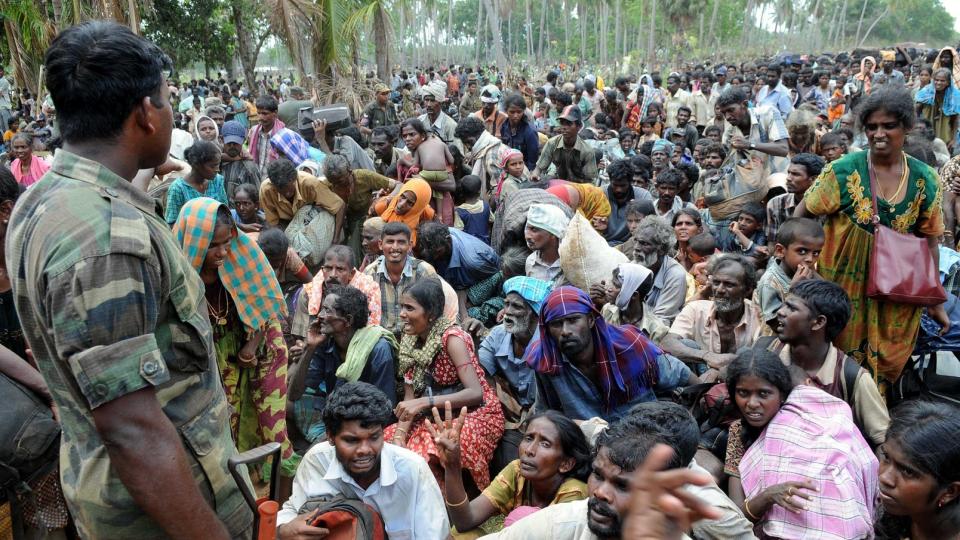 LIDER: En regjeringssoldat holder oppsikt med sivile flyktninger i Putumatalan iPuthukkudiyirippu nord i Sri Lanka. De har flyktet fra omr�der fortsatt kontrollert av Tamiltigrene. Foto: REUTERS/Stringer/SCANPIX