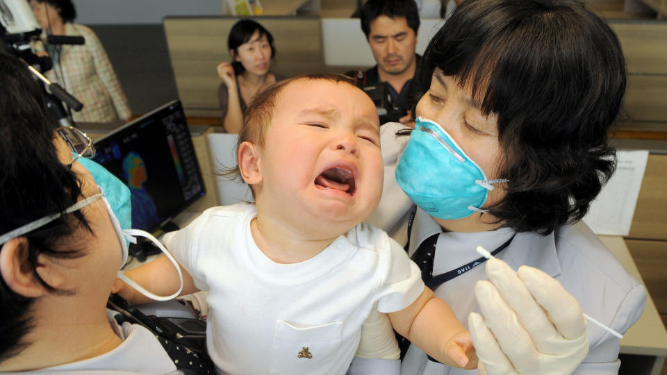SVINEINFLUENSAFRYKT: S�r-Koreanske myndigheter tar pr�ver av en baby som ankom Icheon flyplass fra USA. Foto: SCANPIX/AFP PHOTO/POOL/JUNG YEON-JE