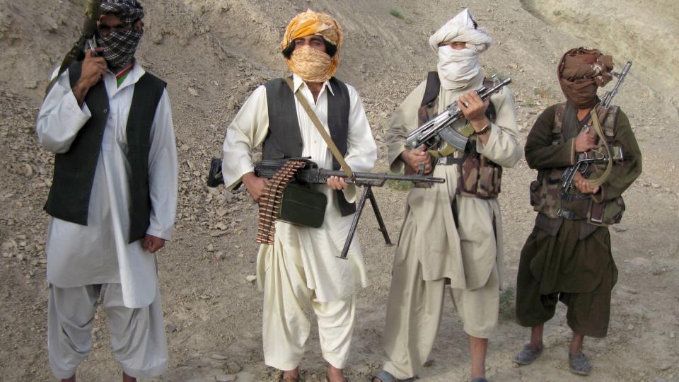 TALIBANKRIGERE I HELMAND-PROVINSEN: Et eller annet sted i de afghanske fjellene lot disse fire krigerne seg avbilde og intervjue i oktober i fjor. Det vi kaller Taliban er imidlertid en mye mer uensartet gruppe enn man kan se for seg. Opiumsbander er for eksempel sentrale, og de kriger ikke av idealisme, men for penger og kartellorganisasjoner. Foto: EPA/STRINGER