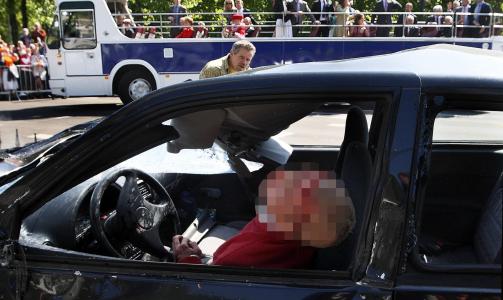 DRAPSMISTENKT: Bilen ble f�rt av en 38 �r gammel, som ble hardt skadd i sammenst�tene. Mannen er mistenkt for attentat mot kongefamilien, som sitter i bussen bak i bildet. I tillegg er han mistenkt for uaksomt eller overlagt drap. Foto: SCANPIX