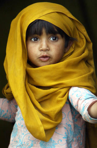 I LEIRE: En pakistansk jente kikker ut av teltet i leiren der hun oppholder seg. Hun er en av de som flyktet fra Buner, da Taliban kom dit. Foto: AP Photo/Mohammad Sajjad/SCANPIX