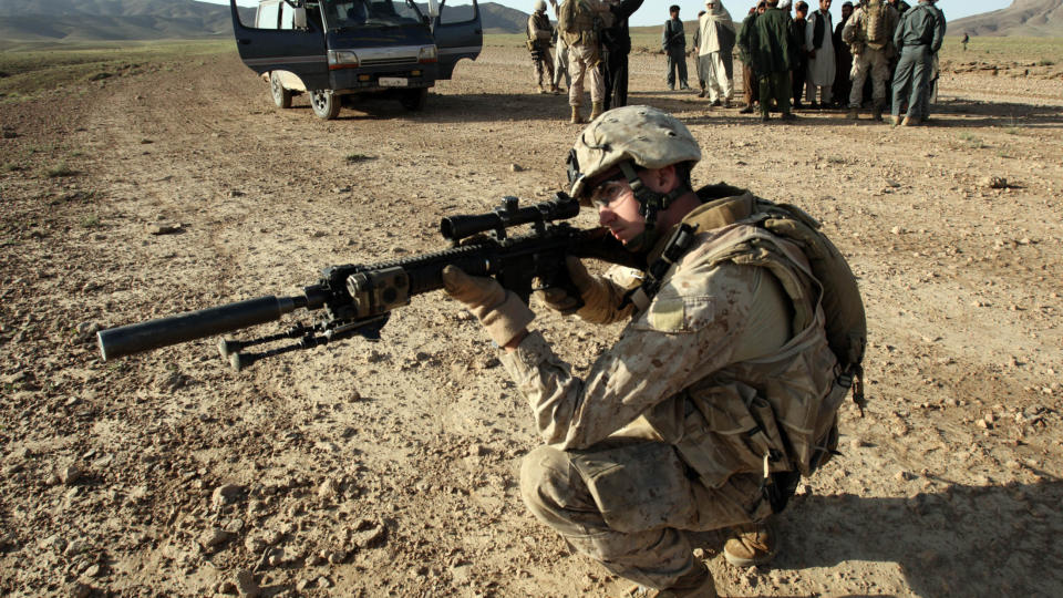 VOLDSOMME KAMPER: En amerikansk soldat holder vakt mens andre ransaker Afghanere for v�pen i Farah-provinsen, der det blir utkjempet voldsomme kamper denne uka. Foto: REUTERS/Goran Tomasevic