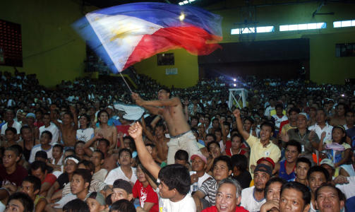 NASJONAL JUBELDAG I FARE: Folk i Manila feiret etter landsmannens triumf. Regjeringen hadde erkl�rt nasjonal jubeldag p� fredag, men den blir det neppe noe av n�r samme regjering n� ber hovedpersonen bli i USA. Foto: Joseph Agcaoili, AFP/Scanpix
