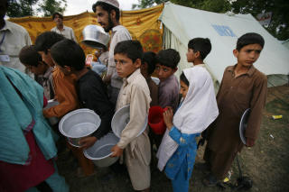 FLYKTNINGLEIRE: Disse flyktningene f�r mat og vann i en flyktningleir i Mardan. Foto: AP Photo/Greg Baker/SCANPIX