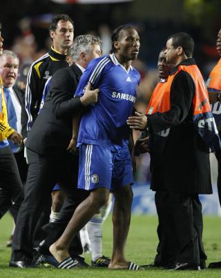 P� BANEN MED SANDALER: Her blir Didier Drogba dratt bort av manager Guus Hiddink. Foto: AP