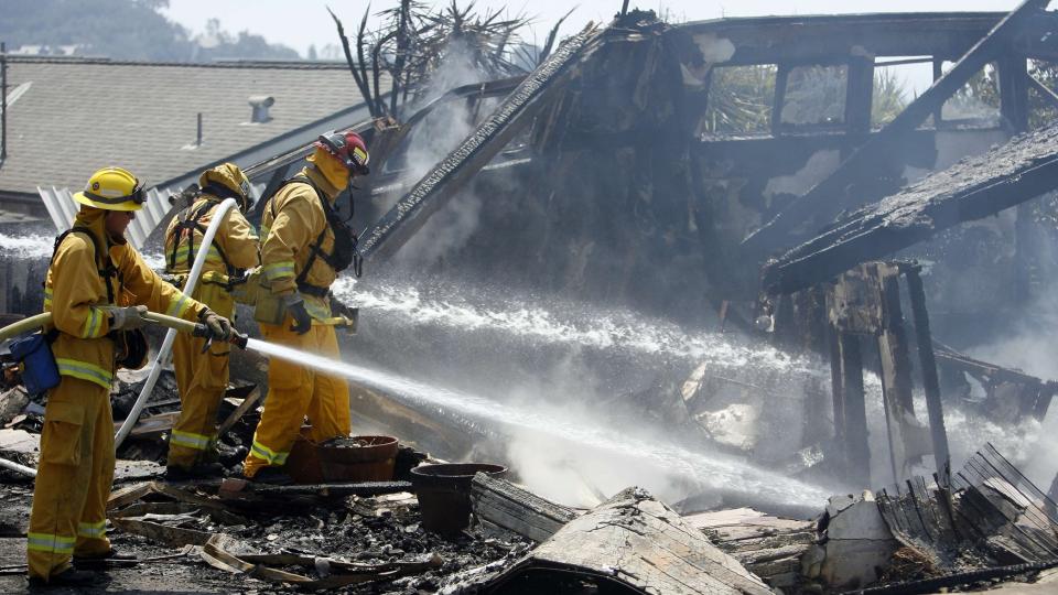 FLYKTER: Brannmenn fors�ker � slukke en brann som allerede har lagt et hus i Santa Barbara i aske. Flere tusen mennesker er p� r�mmen fra �rets f�rste storbrann i California. Foto: REUTERS / Mario Anzuoni / SCANPIX