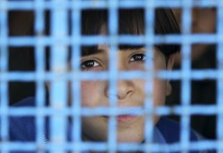 VERDENS ST�RSTE UTEND�RS FENGSEL:  En palestinsk gutt ser ut av vinduet til FNs Faqora-skole, som ble bombet under krigen. FN kom nylig med en rapport der de mente at Israel ikke tok nok hensyn til FNs bygninger under det massive angrepet i desember-januar. Foto: Mohammed Salem/Reuters/Scanpix
