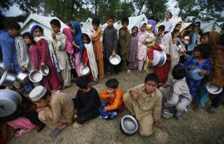 FLYKTNINGLEIRE: Disse flyktningene f�r mat og vann i en flyktningleir i Mardan. Foto: AP Photo/Greg Baker/SCANPIX