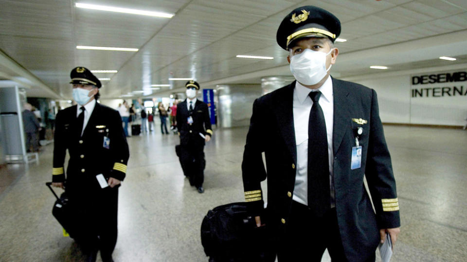 FORHOLDSREGLER: Piloter fra Aeromexico med munnbind p� flyplassen i S�o Paulo i Brasil tidligere i dag. Foto: SEBASTI�O MOREIRA/EPA/SCANPIX