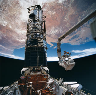 SLIK REPARERES HUBBLE: Romfergen �kj�rer� tett opptil, og s� fanges teleskopet inn med den store armen.Foto: NASA