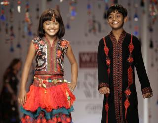 KJENTE FJES: Her viser Azharuddin Mohammed Ismail (til h�yre) og hans medskuespiller Rubina Ali fram kl�r designet av Ashima & Leena Singh i New Delhi. Foto: AP Photo/Mustafa Quraishi/Scanpix