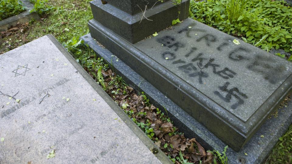 VANDALISME: P� en av gravstenene ved den j�diske gravlunden er det skrevet �krigen er ikke over�. Foto: Berit Roald / SCANPIX