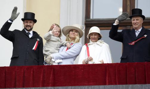 EN VINK: Kong Harald, dronning Sonja, kronprins Haakon, kronprinsesse Mette-Marit og prinsesse Ingrid Alexandra vinker til barnetoget fra Slottsbalkongen i Oslo 17. mai i fjor.  Foto: SCANPIX