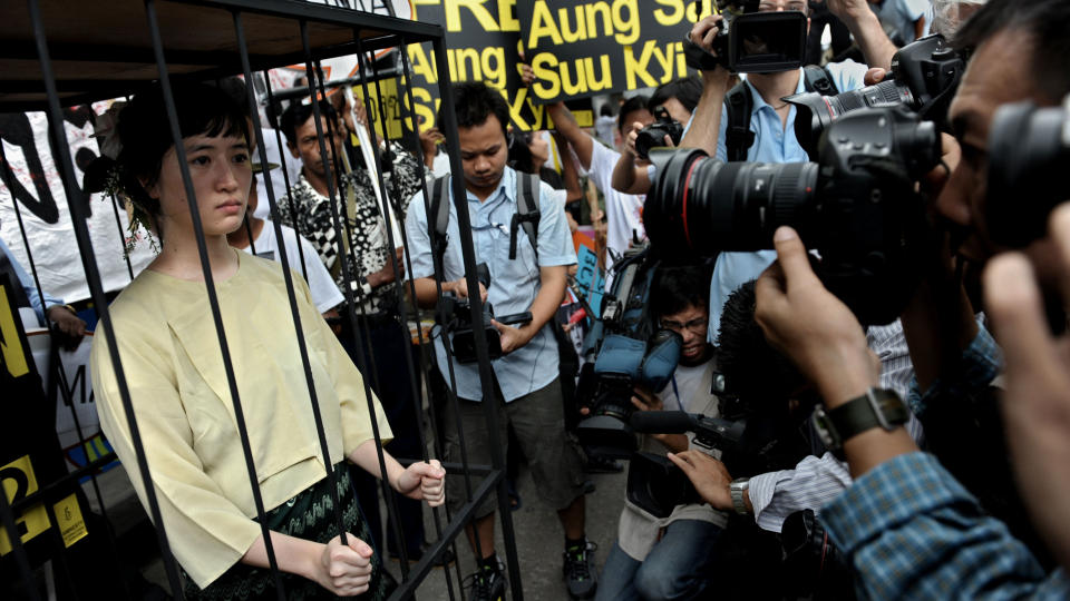 PROTESTERER: En kvinne utkledd som Aung San Suu Kyi er en del av protestene mot rettsprosessen som er satt i gang mot opposisjonspederen. Foto: AFP/EDISON/Scanpix