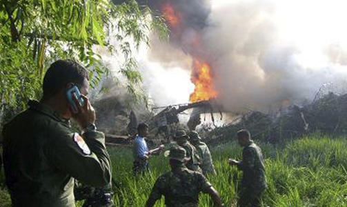 FRYKTER H�YE D�DSTALL: Et millit�rt Hercules-fly styrtet �st p� �ya Java i Indonesia. Flyet traff flere hus og begynte � brenne p� en ris�ker. Foto: SCANPIX/AP Photo/detikSurabaya.com