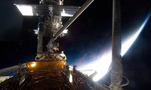 GODT FANGA: Med denne robotarma fikk Atlantis-mannskapet grepet fatt i Hubble, som raser i en fart p� 7500 meter per sekund. Foto: EPA/NASA/SCANPIX