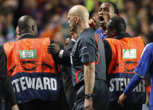 M�TTE BESKYTTES: Vaktene dannet en jernring rundt Tom Henning �vreb� etter at Didier Drogba stormet ut p� banen. Foto: AP