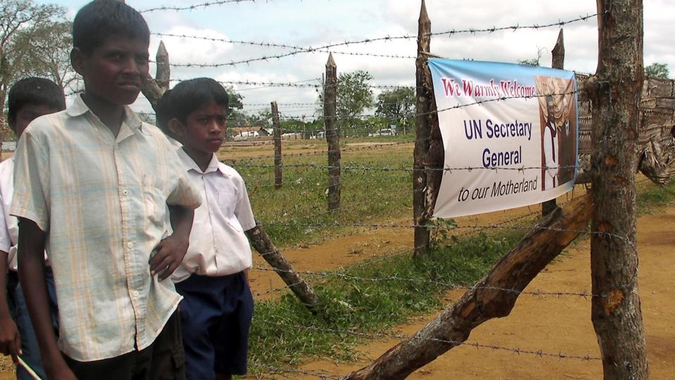 BES�KTE FLYKTNINGLEIR: Tamilske gutter ved siden av en plakat som �nsker FNs generalsekret�r Ban Ki-Moon velkommen til Sri Lanka. Ban legger press p� Sri Lanka om � slippe inn internasjonale hjelpeorganisasjoner til flyktningleiren. Foto: REUTERS/SCANPIX