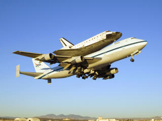 SITTER P�: N�r romferja lander andre steder enn Florida, s� m� den fraktes hjem p� ryggen til en modifisert B747 jumbojet. Foto: SCANPIX/AFP PHOTO/HO/NASA
