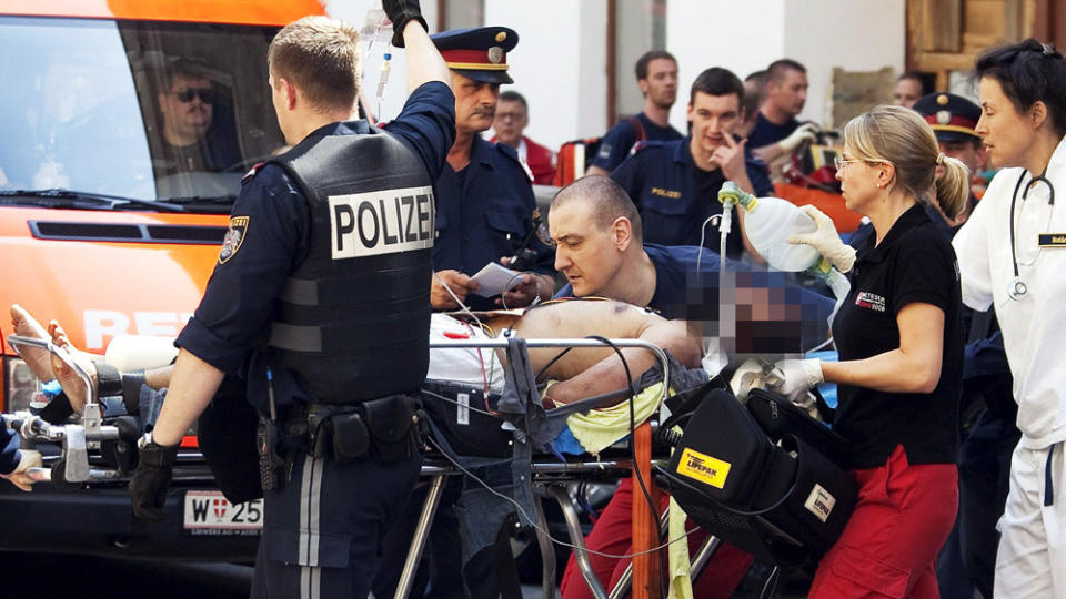 S�RET: En ikke identifisert s�ret mann fraktes ut av tempelet og inn i en ventende ambulanse. Foto: BENEDIKT L�BELL/EPA/SCANPIX