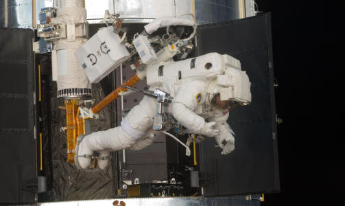 I ARBEID: �Metallpistolen� som astronauten p� bildet over har hengende i beltet, er en av flere driller som er spesiallaget for Hubble-ferdene. Foto: NASA