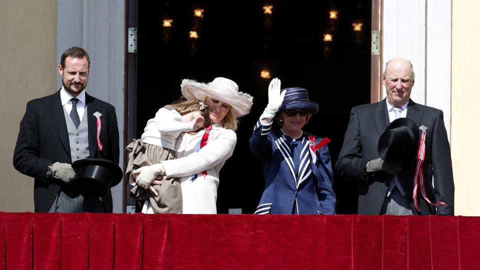 P� BALKONGEN: 17. mai i �r. Fra v: kronprins Haakon, prinsesse Ingrid Alexandra, kronprinsesse Mette-Marit, dronning Sonja, og Kong Harald,  p� Slottsbalkongen i Oslo 17. mai. Mette Marit b�rer en sliten Ingrid Alexandra. N� flytter kronprinsfamilien inn p� slottet. I allefall for en stund. 
Foto: Knut Falch / SCANPIX