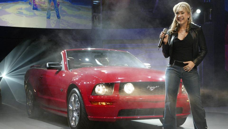 I RAMPELYSET: Diana DeGarmo, som her synger under avdukingen av den nye Ford Mustang GT - f�r finanskrisen - i 2005, har f�tt merke baksiden ved et liv i rampelyset. Foto: EPA/BRENDAN MCDERMID/Scanpix
