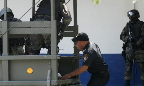 TAS MED:  En politimann beordres inn i en lastebil etter � ha blitt anholdt av den mexicanske h�ren som er satt inn i kampen mot narkokartellene i landet. Foto: AP Photo