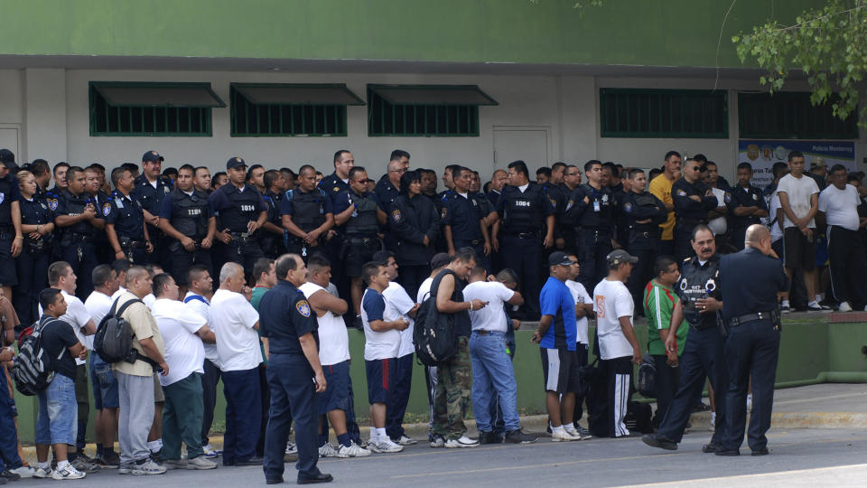 25 ARRESTERT:  Minst 25 politiansatte er arrestert i Mexico, mistenkt for ulovlig kontakt med narkotikabander. Her venter de p� � bli avh�rt utenfor politistasjonen i Monterrey. Foto: Ap Photo