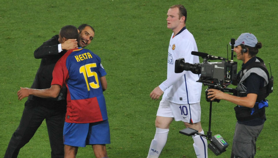 VIL GLEMME ROMA: Josep Guardiola gratulerer Seydou Keita, mens en skuffet Wayne Rooney passerer dem p� Stadio Olimpico i Roma. Foto: AFP