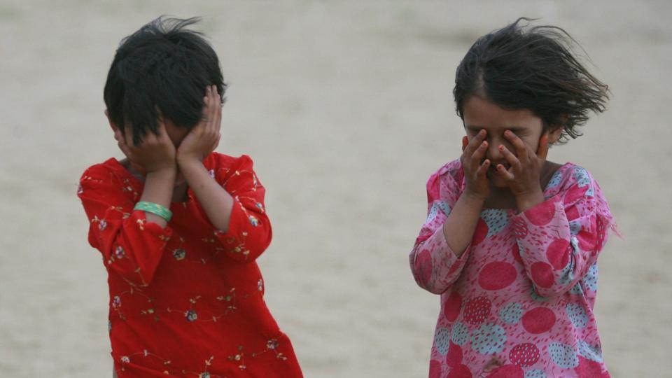 M�TTE FLYKTE: To sm� jenter beskytter seg mot en sandstorm i flyktningeleiren i Swabi-distriktet, omtrent 120 kilometer nord for Islamabad. If�lge FN har n�rmere 2,5 millioner mennesker m�tte flykte fra Swat-dalen som f�lge av Talibans angrep og krigen mot pakistanske myndigheter. Foto: Faisal Mahmood/Scanpix