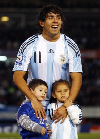TAPTE I NATT: Tevez stilte opp til bilde med en guttunge i United-bortedrakt i natt. Datteren Florencia (t.h) har p� seg en Argentina-drakt, som pappa. Foto: REUTERS/Enrique Marcarian