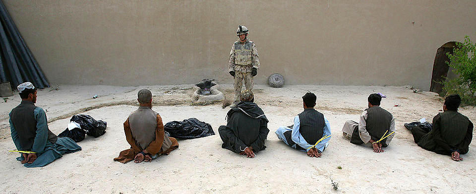 FANGET:  Over 100 fanger d�de mens de ble mishandlet i et nettverk av amerikanske og allierte avh�rskamre. Her voktes fem av ti mistenkte medlemmer av Taliban i Afghanistan. Foto: JOHN D. MCHUGH/AFP/SCANPIX