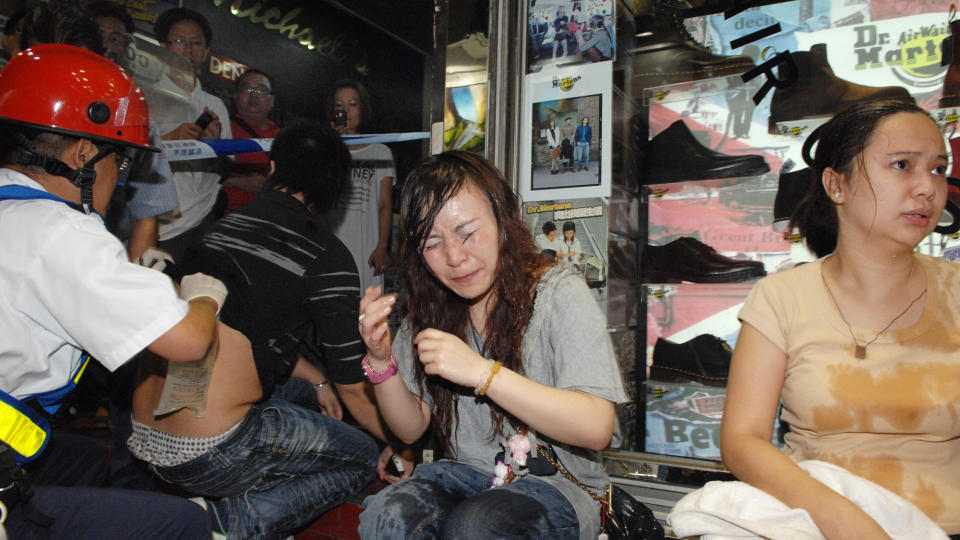 OFRE: Noen av ofrene fors�ker � f� bort syren etter � ha blitt utsatt for et helt tilfeldig syreangrep p� �pen gate. Foto:AP Photo/Ming Pao-Wei Wing Hong/SCANPIX