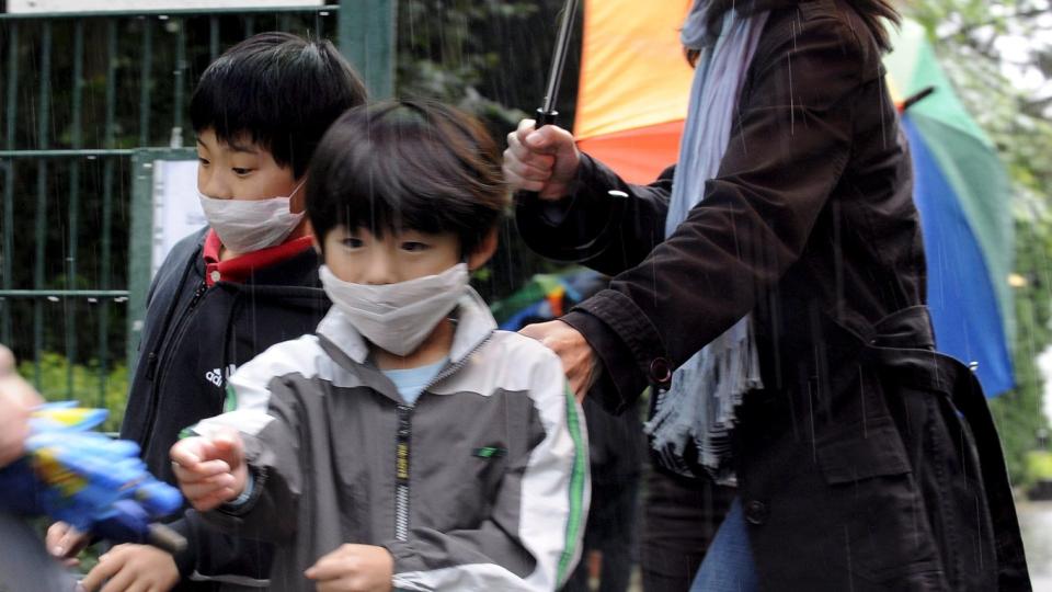 GLOBAL PANDEMI: En familie forlater Japan International School i D�sseldorf i Tyskland etter en svineinfluensatest i dag. Mer enn 30 elever ved skolen er smittet av svineinfluensaen. N� er det ventet at WHO erkl�rer svineinfluensaen som en global pandemi. Foto: EPA/ACHIM SCHEIDEMANN