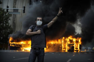 BY I BRANN: Demonstranter har satt fyr p� en buss i Teheran. Foto: Scanpix/AFP PHOTO/OLIVIER LABAN-MATTEI