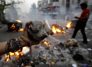 KASTET STEIN: Rasende reformtilhengere kastet stein og glass mot politiet. De svarte med � bruke t�regass og k�ller. Foto: REUTERS/Ahmed Jadallah/SCANPIX