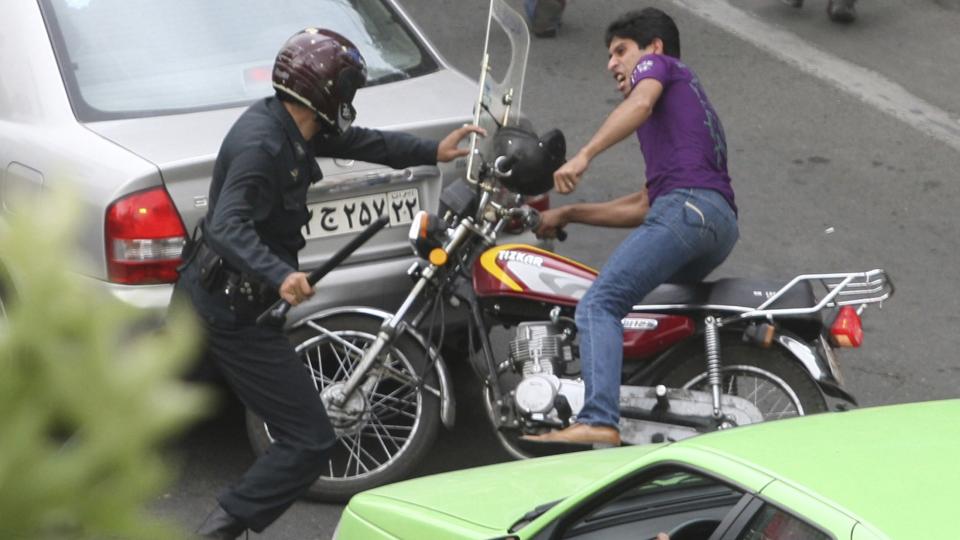 HARDTSL�ENDE: Her blir en motorsyklist angrepet av politi med k�lle i Teheran i dag. Foto: REUTERS/Stringer/SCANPIX